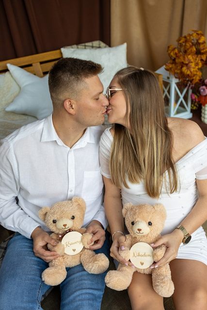 Para w oczekiwaniu całuje się, trzymając dwa pluszowe misie