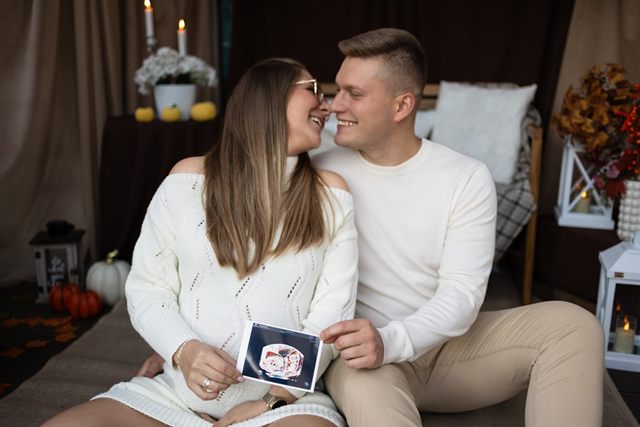 Para siedzi ze zdjęciem USG w dłoniach